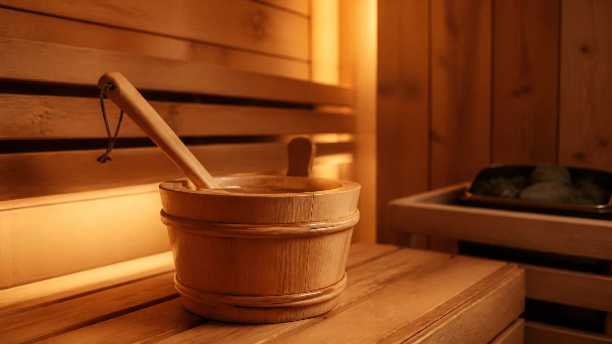 Wooden sauna bucket and ladle on a cedar bench