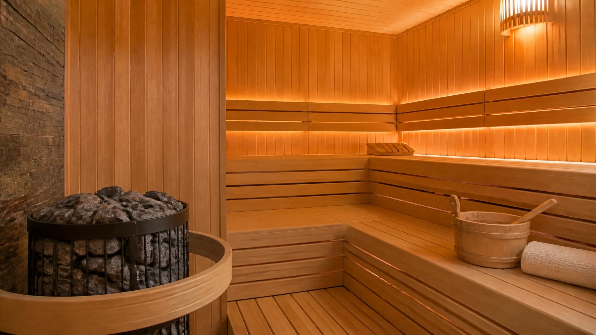 Interior of a traditional dry sauna with wooden benches and a stone heater